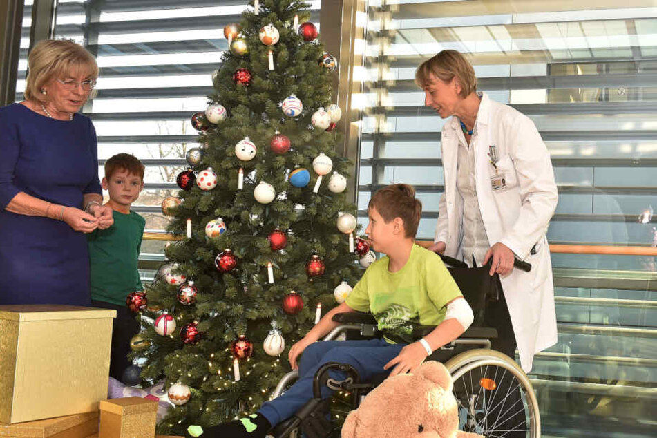Ursula Herrmann (l.), Und Prof. Angela Hübner schmücken mit den kleinen Patienten Ron (9, r.) und Vincenz (6) den Tannenbaum in der Kinderklinik des Uniklinikums.