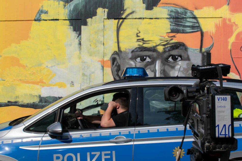 Ein Polizeiwagen steht vor dem Wandbild des ermordeten Nidal R.