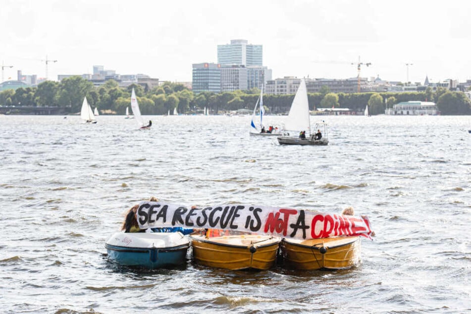 Mit einem Banner demonstriert die St. Pauli-Segelabteilung auf der Außenalster für die freie Seenotrettung im Mittelmeer.