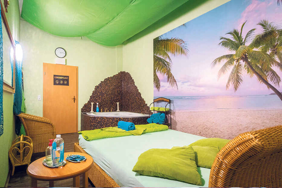 Das "Karibik-Zimmer" wartet mit Badewanne und Palmen-Tapete auf.