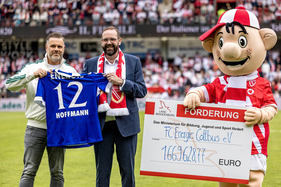 Sportminister Gordon Hoffmann (47, M.) übergibt Präsident Sebastian Lemke (42, l.) den lang ersehnten Scheck.