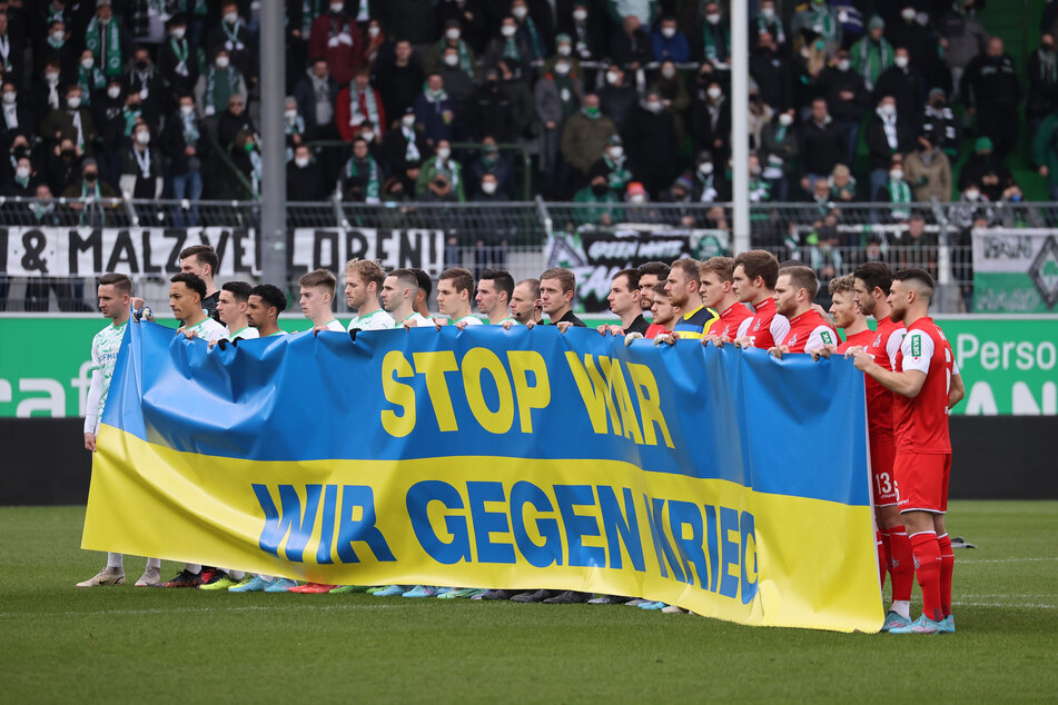 Ukraine-Solidarität: "STOP WAR - WIR GEGEN KRIEG" steht auf dem Banner der SpVgg Greuther Fürth und des 1. FC Köln, das beide Mannschaften am Samstag vor Anpfiff entrollten.