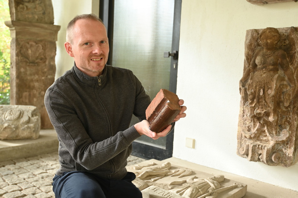 Stefan Thiele (41), Kurator im Schloßbergmuseum, zeigt im Lapidarium einen Stein der zerstörten St.-Nikolaikirche.