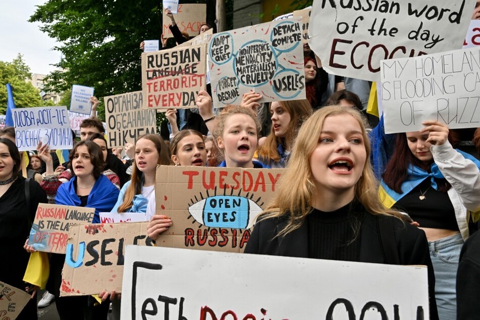 Ukrainian students hold placards denouncing ecocide during a rally outside of United Nations office in Kyiv.