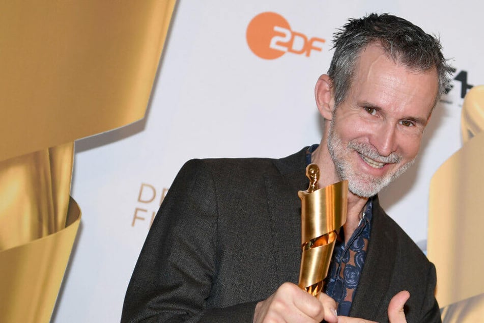 Ulrich Matthes, Präsident der Deutschen Filmakademie, zeigt auf den Preis, die Lola, bei der Bekanntgabe der Nominierungen für den Deutschen Filmpreis 2019.