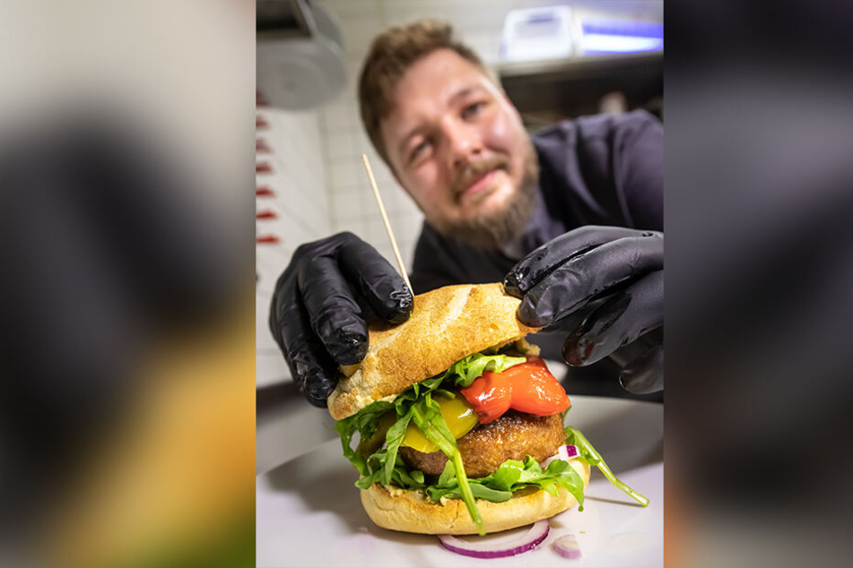 Der stellvertretende Küchenchef Thomas Brandt (29) bereitet den veganen "Beyond Meat Burger" zu.