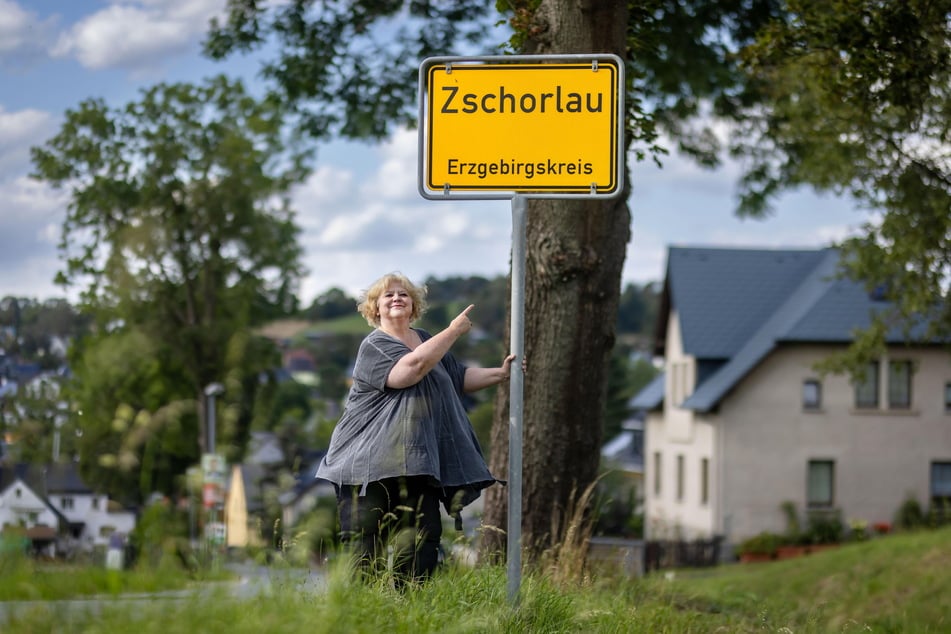 Autorin Claudia Puhlfürst (61) steht am Ortseingang Zschorlau.