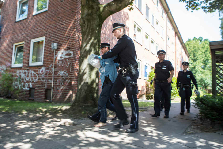 Polizisten führen den Mann ab.