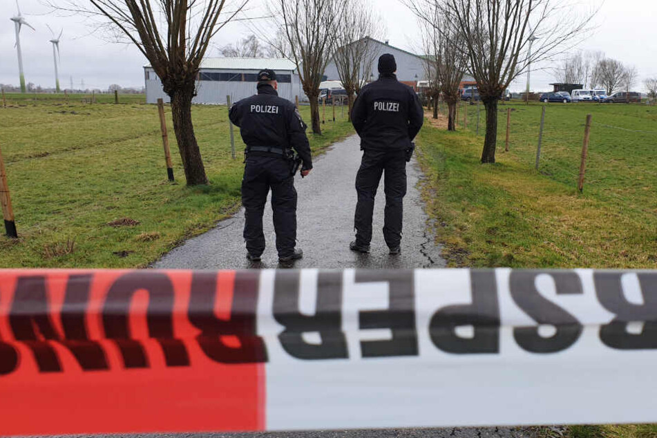 Polizisten sperren den Bauernhof in Dammfleth während der Durchsuchung ab.