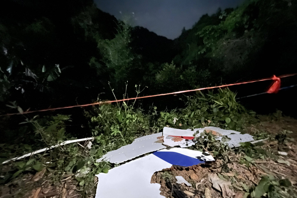 Plane debris from the wreckage scattered around the hills in the southern Chinese province of Guangxi.