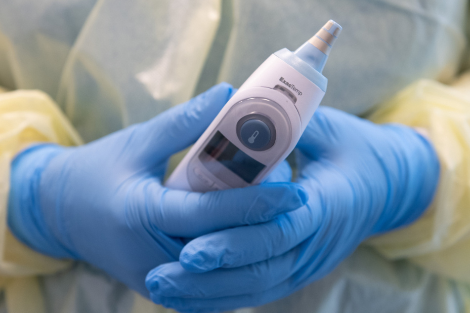 Eine Krankenschwester hält einen Ohrthermometer in der Hand. (Symbolbild)