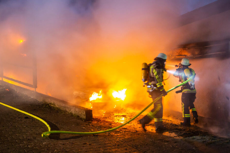 Zwei Feuerwehrleute bei den Löscharbeiten des Vereinsheims.