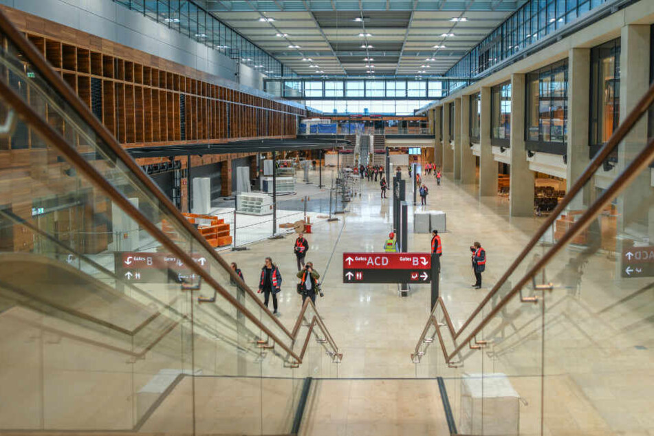 Journalisten gehen durch das Terminalgebäude des Hauptstadflughafens Berlin Brandenburg Willy Brandt (BER). Der Flughafen soll am 31. Oktober eröffnen.
