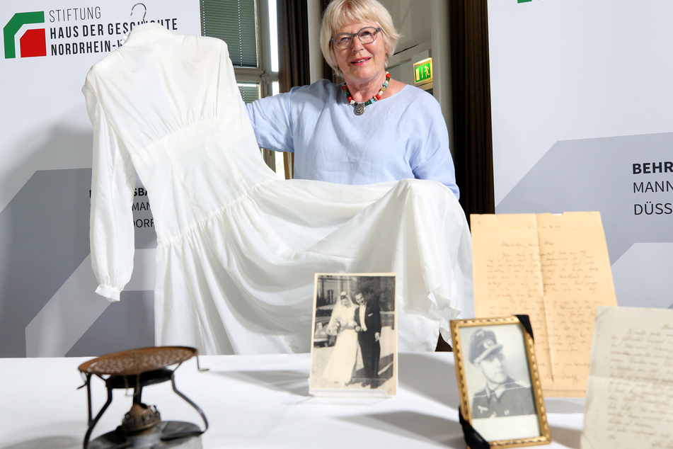 Inge Abresch, Gattin des Sammlungsgründers, zeigt ein Brautkleid aus Fallschirmseide. Das Haus der Geschichte NRW hat die besonderen Schätze angekauft.