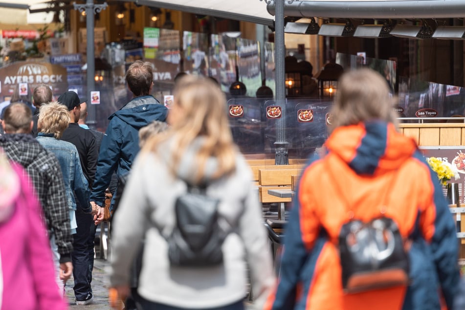 Passanten laufen durch die Münzgasse in der Altstadt an Freisitzen vor Restaurants, die mit Plexiglasscheiben getrennt sind, entlang. Unter strengen Hygieneauflagen darf die Gastronomie im Freistaat seit dem 15. Mai wieder öffnen.