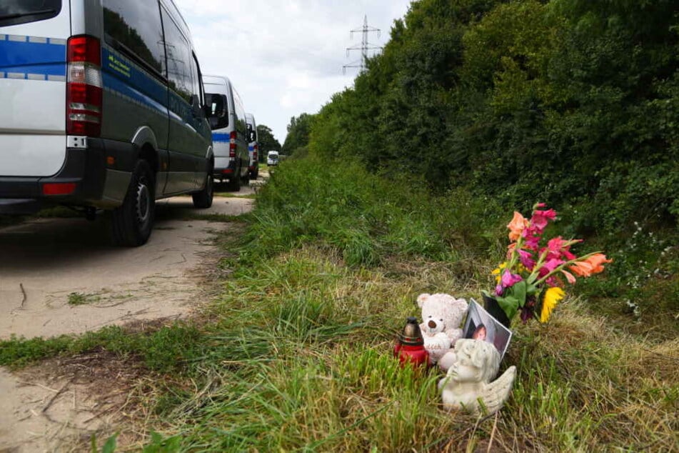 Ein Teddybär und Blumen erinnern am Fundort der Leiche an das Verbrechen.