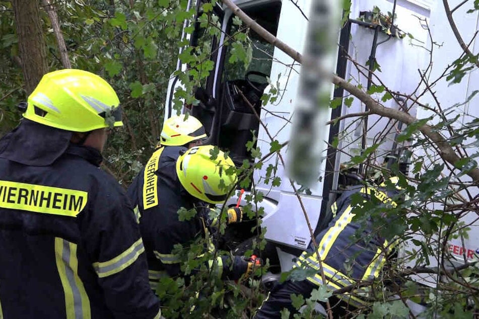Einsatzkräfte der Feuerwehr inspizieren den Lastwagen.