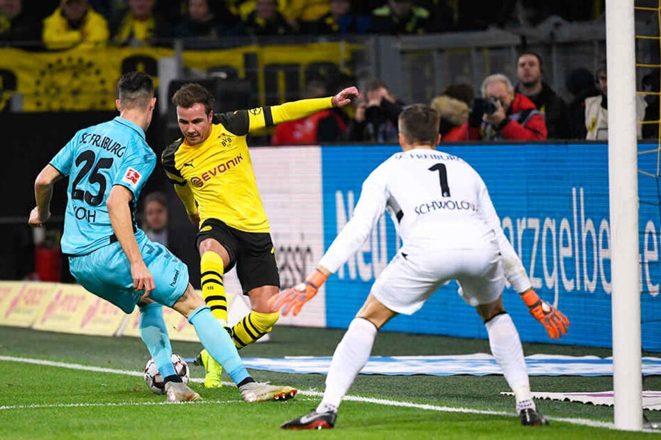 BVB-Stürmer Mario Götze versucht an Freiburgs Abwehrmann Robin Koch (l.) und SCF-Keeper Alexander Schwolow (r.) vorbeizukommen.