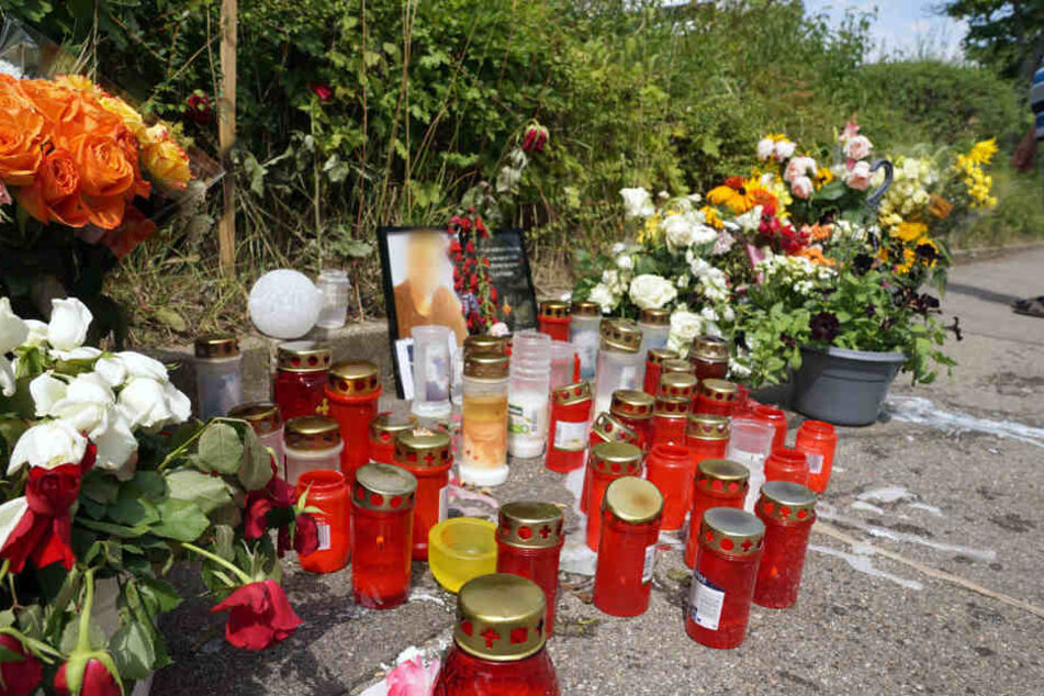 Kerzen und Blumen stehen am Tatort um ein Porträt des dort getöteten Mannes herum.