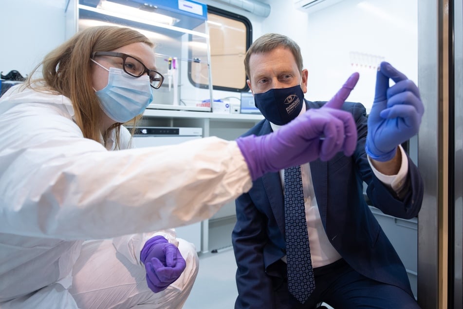 Sachsens Ministerpräsident Michael Kretschmer zusammen mit einer Assistentin des Fraunhofer-Instituts Aachen in einem Prototyp des neuen Corona-Testmobils.