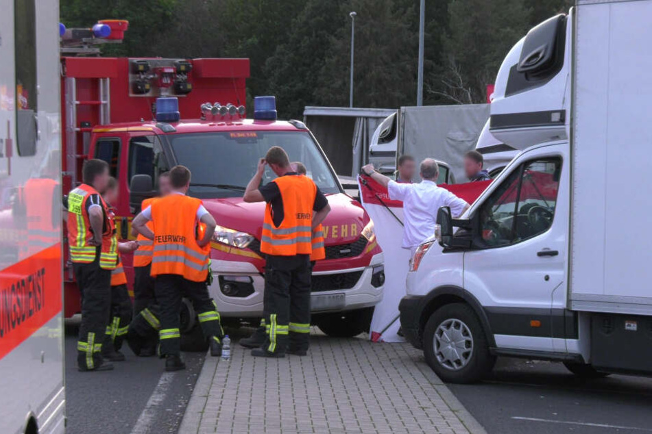 Rettungskräfte stehen an der Unglücksstelle.
