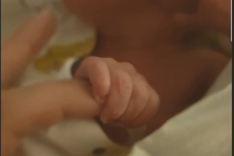 Aaliyah Jeyla hält den Finger ihrer Mutter fest.