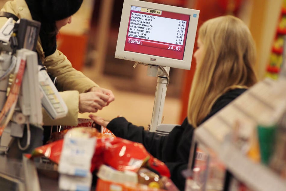 Eine Frau bezahlt ihren Einkauf an der Supermarktkasse - ein veraltetes Konzept?