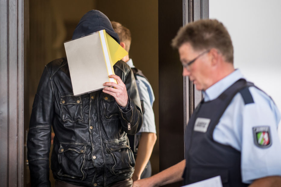 Der Angeklagte Alfred P. wird beim Prozessauftakt im Landgericht in Paderborn von zwei Justizbeamten in den Sitzungssaal geführt.