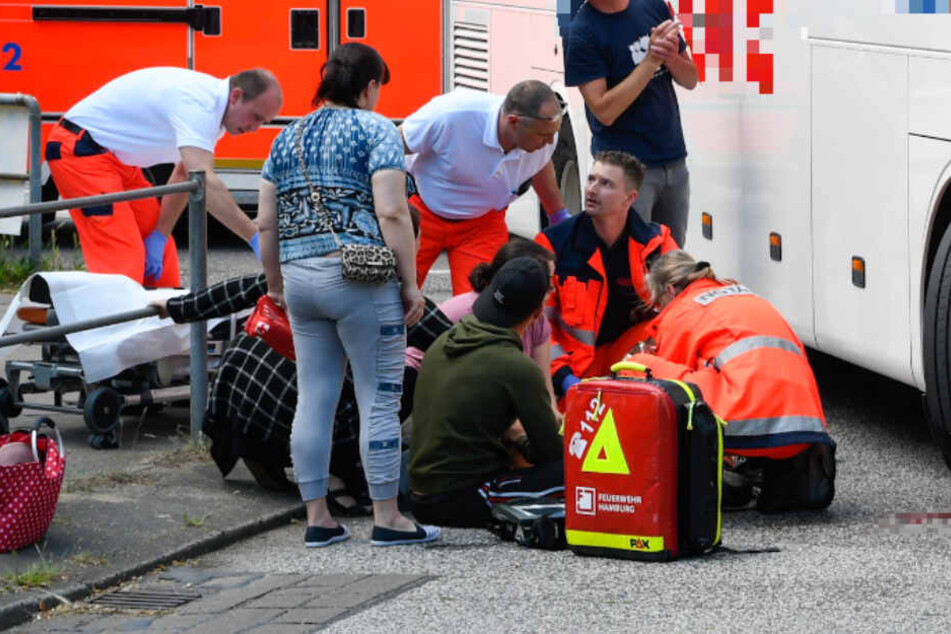 Ersthelfer kümmern sich um das Kind, das von dem Bus erfasst wurde.
