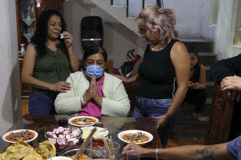Maria Del Carmen Acero Camacho (M) betet neben ihrer Tochter Ana (r) und ihrer Schwester Margarita.