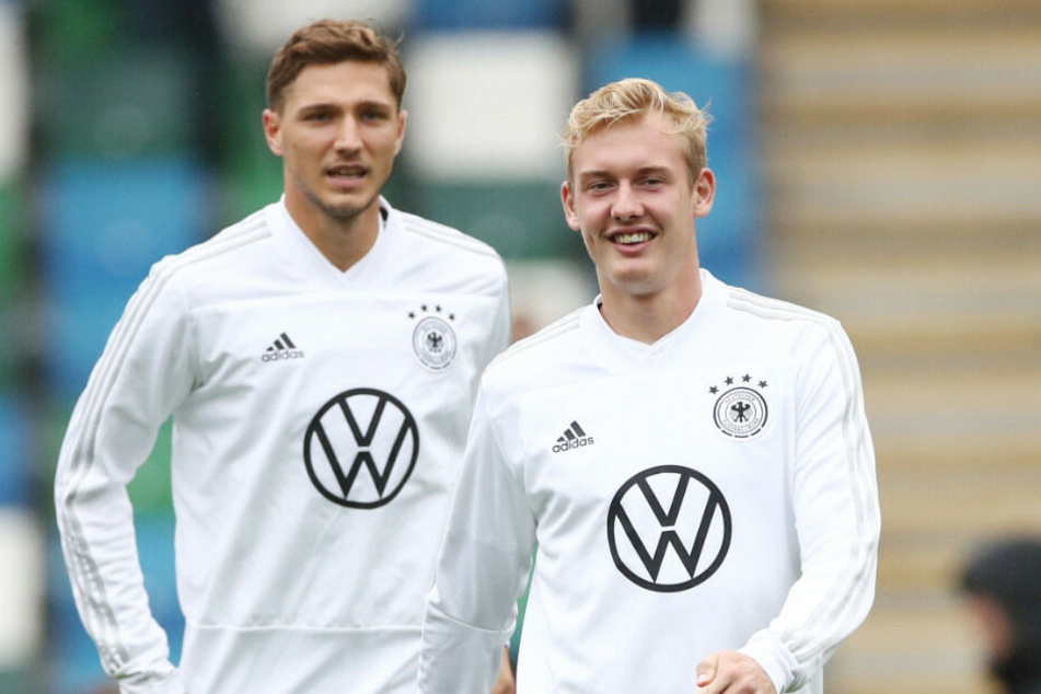 Julian Brandt (r.) und Niklas Stark wärmen sich vor dem Spiel in Nordirland auf.