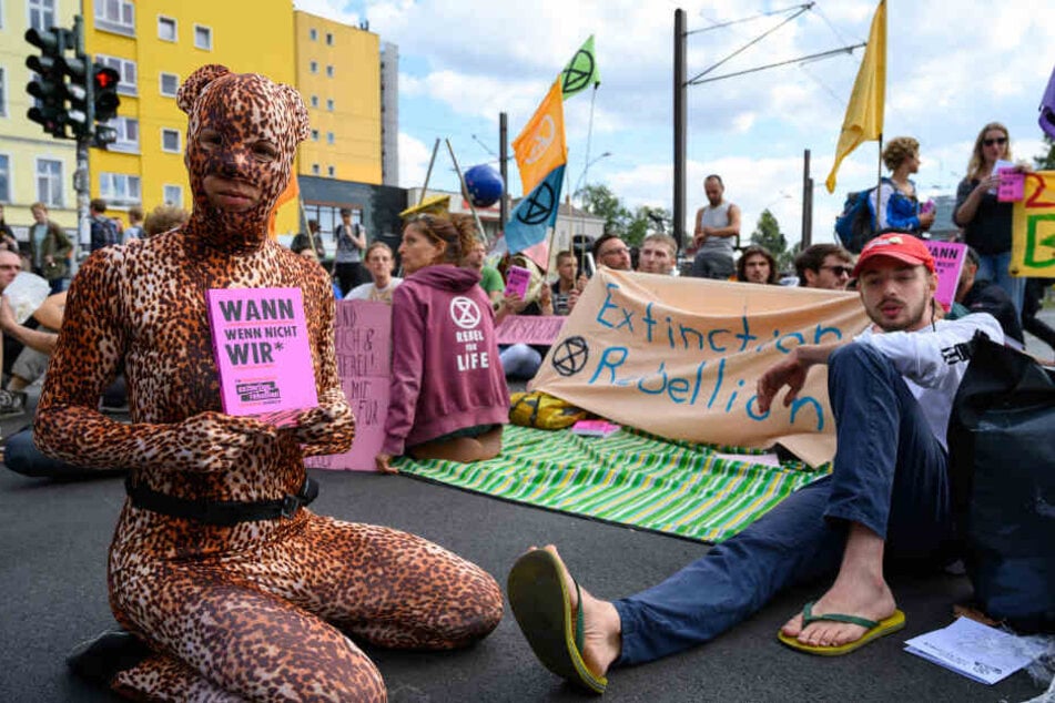 Klimaaktivisten der Bewegung "Extinction Rebellion" blockieren nach einer Pressekonferenz die Warschauer Straße und verteilen ihr Buch "Wann wenn nicht wir". (Archivbild)