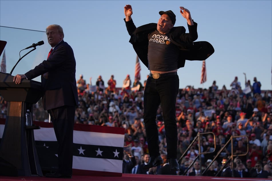 Elon Musk (53) springt auf der Bühne, während Donald Trump bei einer Wahlkampfveranstaltung bei der Butler Farm Show spricht.