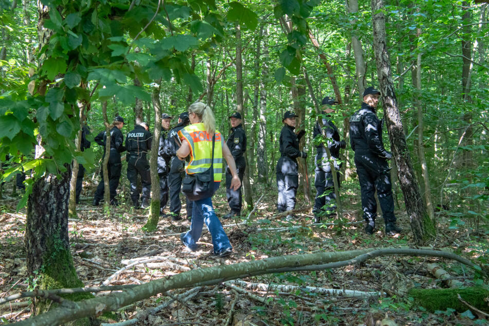 Polizisten bei der Suche nach den Leichen in einem Waldstück bei München. (Archiv)