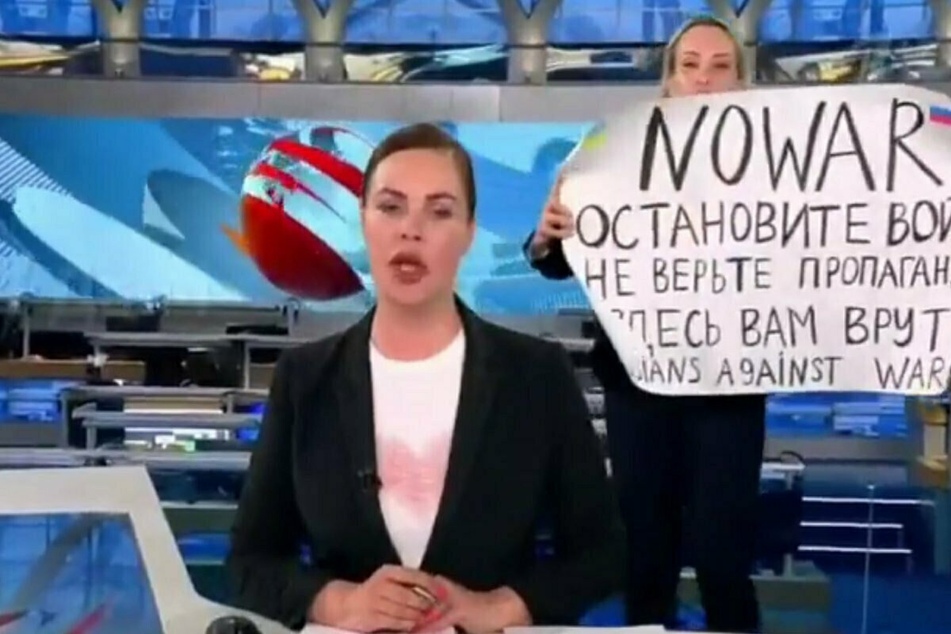 Marina Ovsyannikova (r.) interrupted the evening news and held up an anti-war sign.