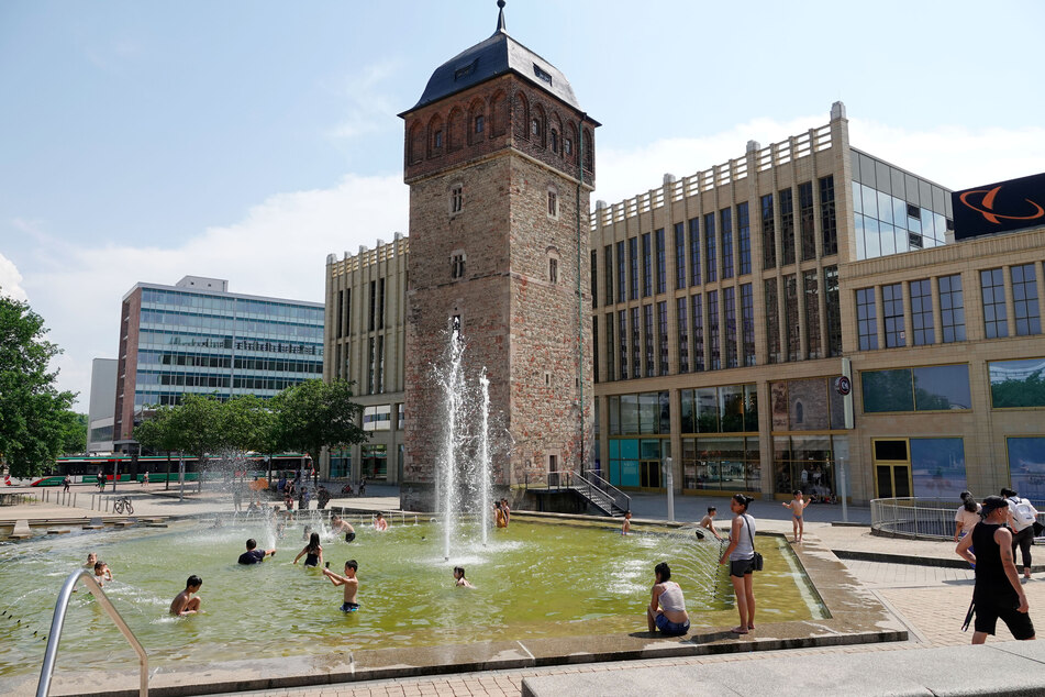 Ein beliebter Ort an heißen Tagen: Der Brunnen im Chemnitzer Stadthallenpark. Bei der Hitze sollte man den Körper kühl halten.