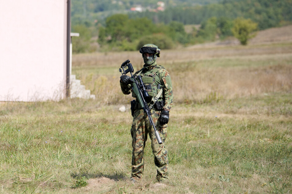 Ein serbischer Soldat steht auf einem Feld vor einem Haus in der Nähe des Ortes Rudnica, der sich an der Grenze zum Kosovo befindet.