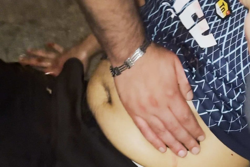 Mit Händen wird eine Wunde im Bauch nach Messerangriff zugehalten, bis die Rettungshelfer eintreffen.