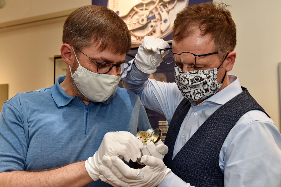 Mueumsdirektor Ulf Molzahn (53, r.) schaut sich mit Kurator Jürgen Franke (49) die älteste Uhr der Ausstellung an - die Herrentaschenuhr „Lange 106“.