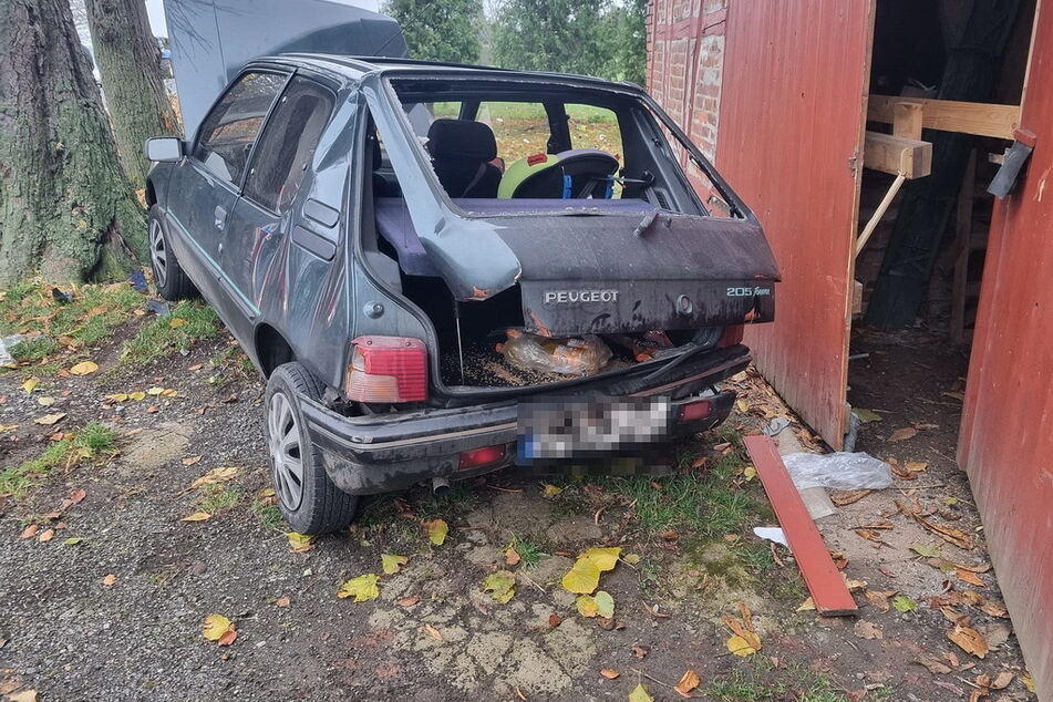 Der Aufprall war heftig! Ein neben der Fahrbahn geparkter Peugeot wurde in ein Scheunentor geschleudert.