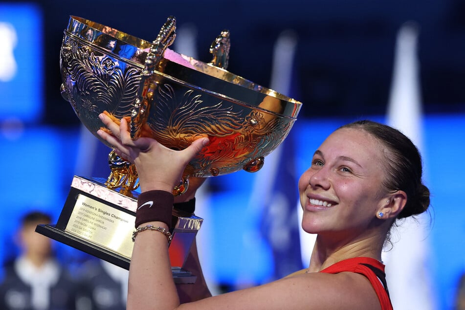 Amanda Anisimova of the US celebrates with the trophy after winning her singles final match against Czech Republic's Linda Noskova at the China Open in Beijing on October 5, 2025.