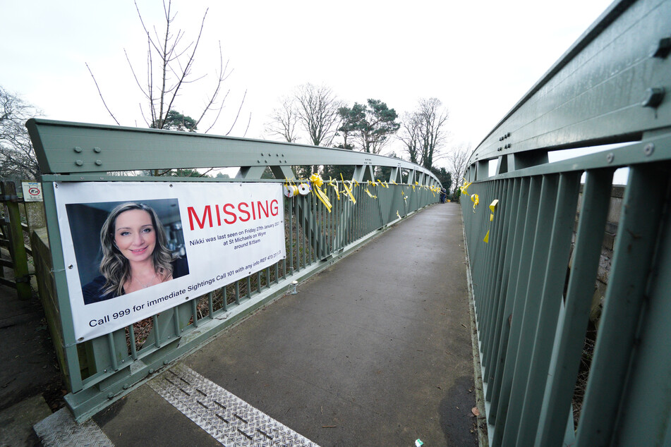 Ein Plakat mit einem Vermisstenaufruf für Nicola Bulley (45) und gelbe Bänder mit Hoffnungsbotschaften, die an einer Brücke über den Fluss Wyre befestigt sind. Die Frau verschwand am 27. Januar, als sie mit ihrem Springer-Spaniel Willow spazieren ging.
