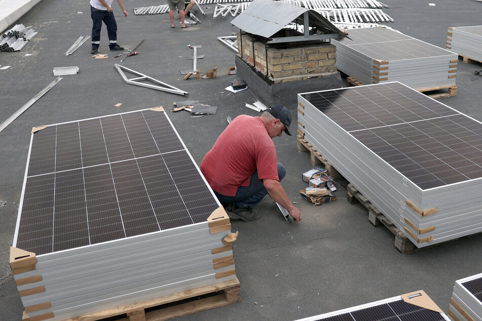 Workers are installing solar panels on the roof of Maternity House No. 3 during a partial electricity blackout in Kyiv on June 14.