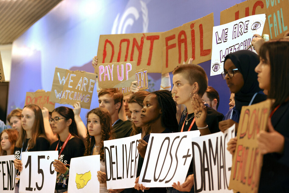 Young climate activists hold up signs urging COP27 delegates to find a way forward.