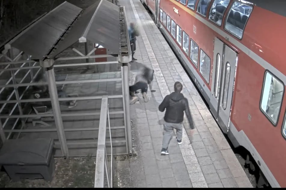 Die Überwachungskamera zeichnete auf, wie der Mann (r.) unvermittelt auf sein Opfer (M.) eintrat.