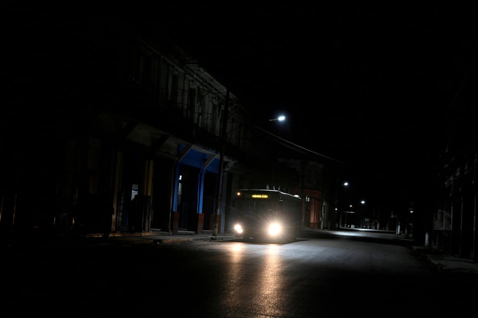 A bus drives along a dark street in Havana as Cuba begins efforts to restore power after its grid collapsed for the second time in a week on March 22, 2026.