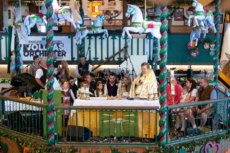 Pfarrer Sascha Ellinghaus tauft beim traditionellen Wiesngottesdienst im Marstall-Festzelt auf der Theresienwiese vier Schaustellerkinder.