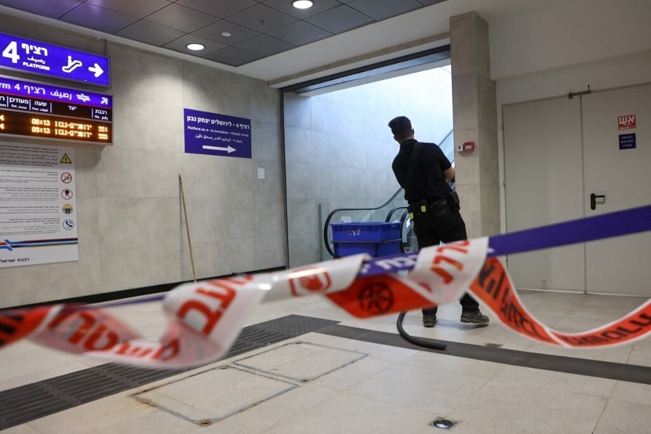 A member of the Israeli security forces stands guard inside a train station damaged after a missile was fired from Yemen, in the town of Modin.