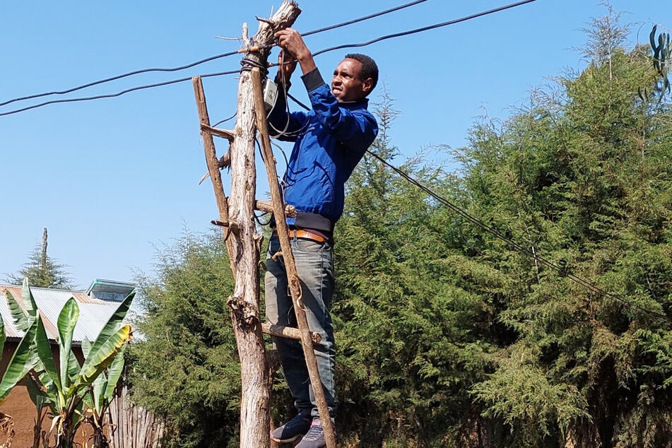 Tulas Haupttechniker Misgano montiert nach einer Masterneuerung die Halterungen für die Leitungen.