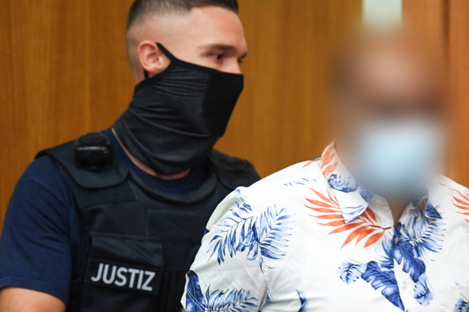 Ein Justizbeamter führt den 41-jährigen Angeklagten (r) zum Prozessauftakt in den Gerichtssaal des Frankfurter Landgerichts.